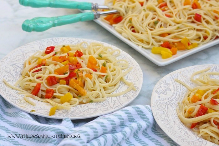 Linguini with Sweet Bell Peppers and Serrano Chili on two white plates and a white platter with turquoise serving spoons
