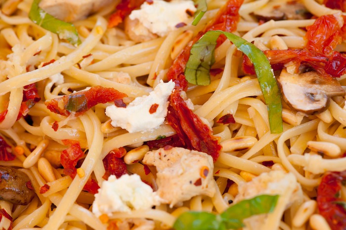 A close up of Linguini with Chicken and Goat Cheese garnished with basil chiffonade