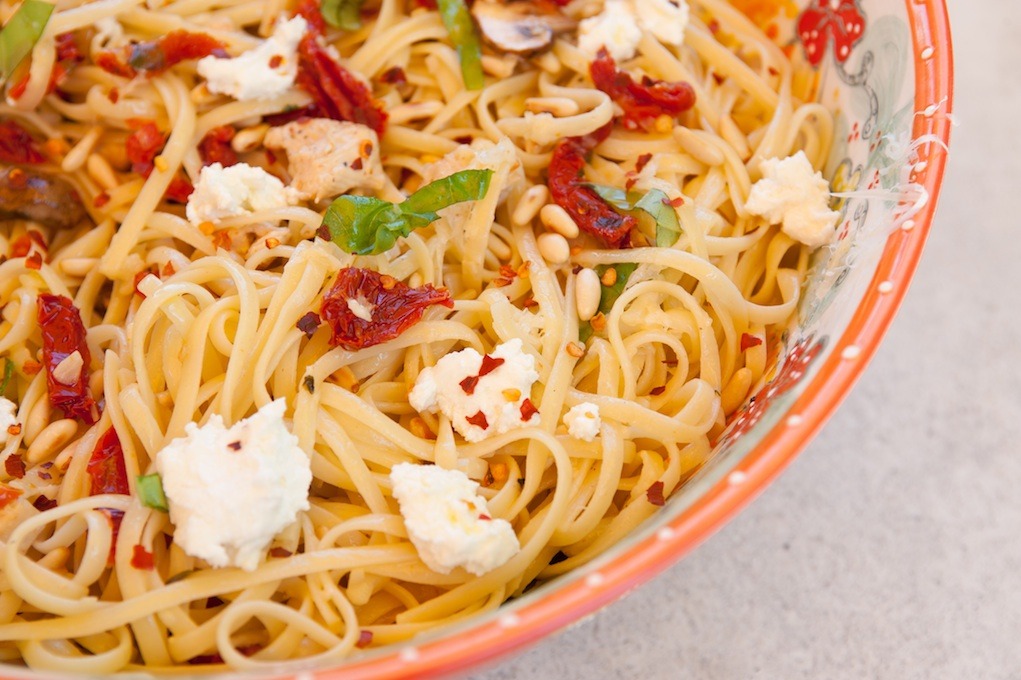 A close up photo Linguini with Chicken and Goat Cheese #linguini in an orange bowl set on grey stone backdrop