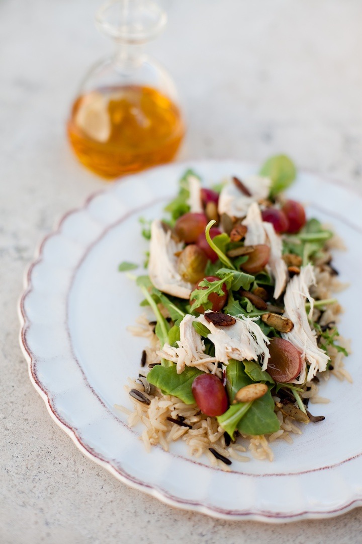 Wild Rice and Arugula Chicken Salad with Pear Chardonnay Vinaigrette on white plate set on a marble surface