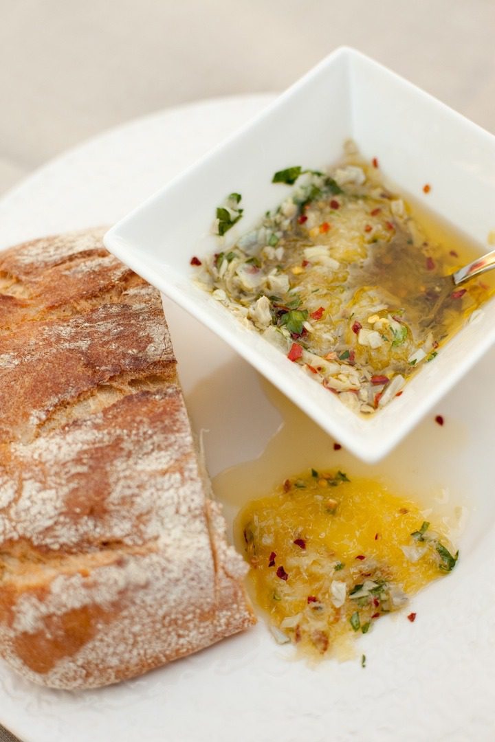 Parmesan Artichoke Heart Dipping Oil with bread on white dish