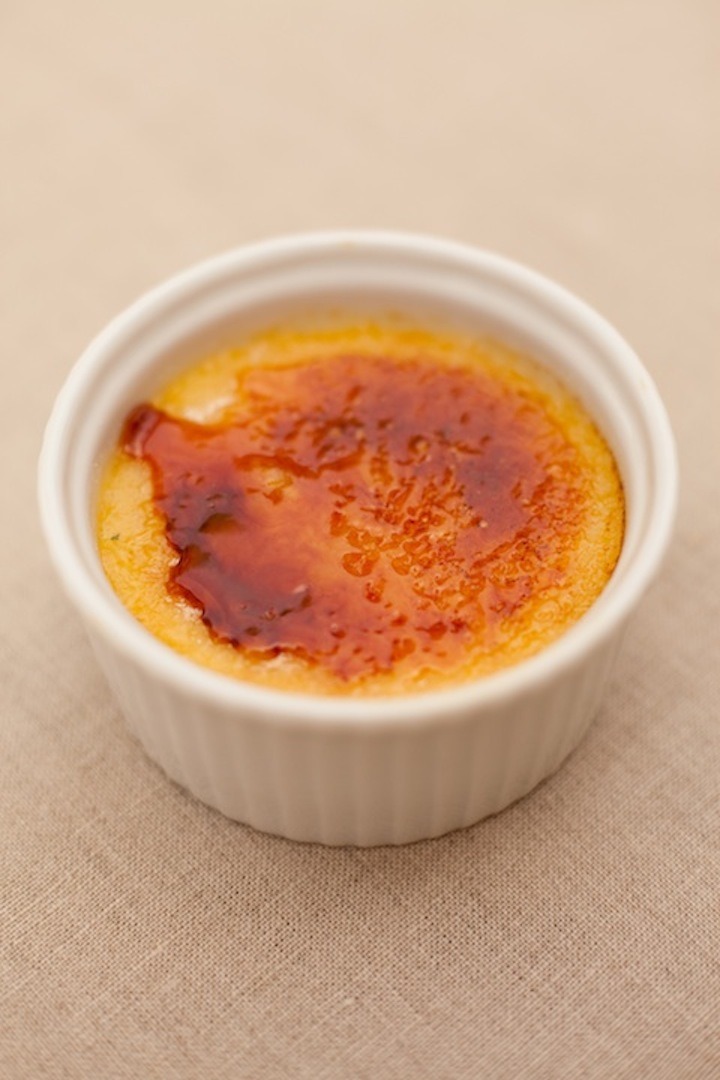 Orange Vanilla Creme Brûlée in white ramekin on beige tablecloth