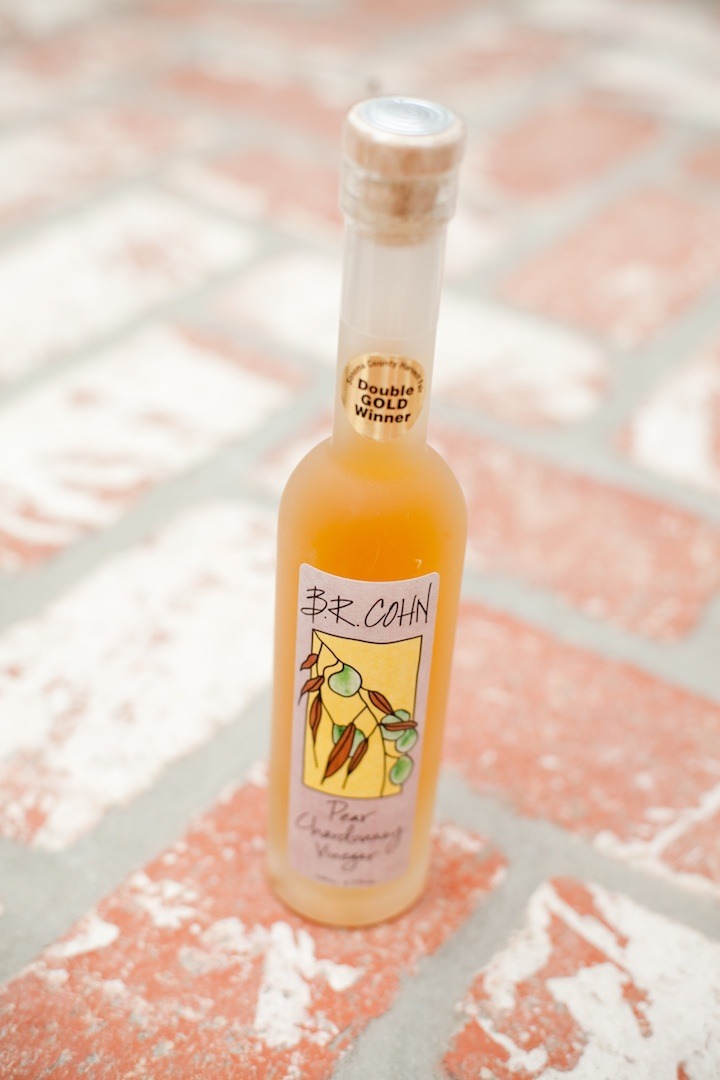 A bottle of Pear Chardonnay Vinegar on brick surface
