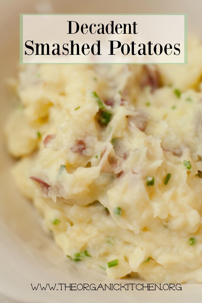 A close up of Decadent Smashed Potatoes in a white bowl