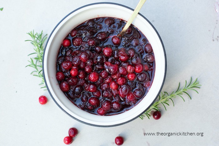 Cranberry Sauce in white bowl garnished with rosemary