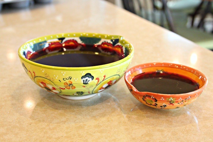 Two bowls of pomegranate juice, one before reduction, one after. 