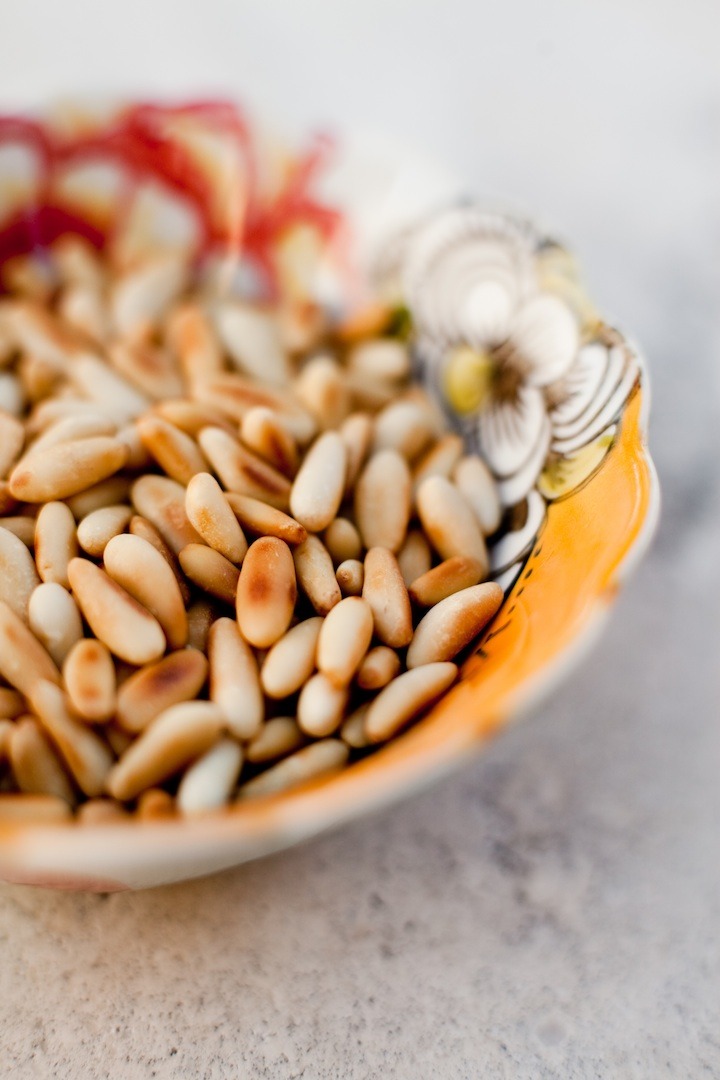 A colorful bowl filled with pine nuts