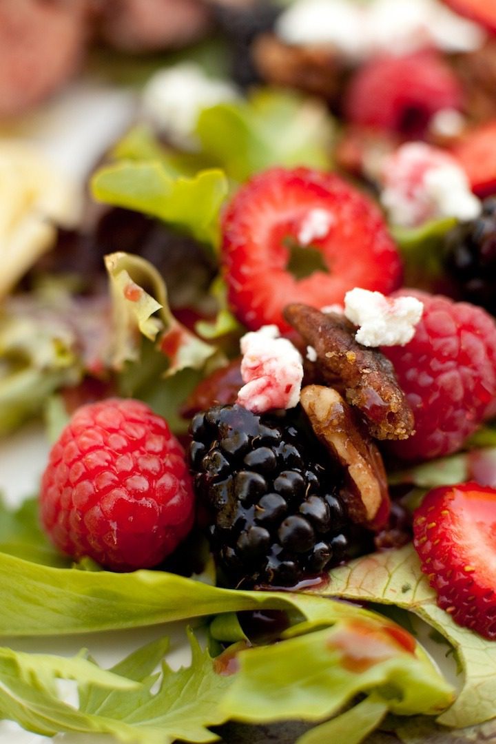 A berry salad on lettuce with feta and pecans