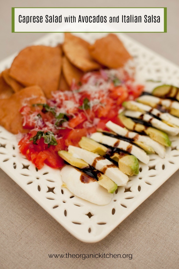 A white plate on beige table cloth filled with Caprese Salad with Avocados and Italian Salsa