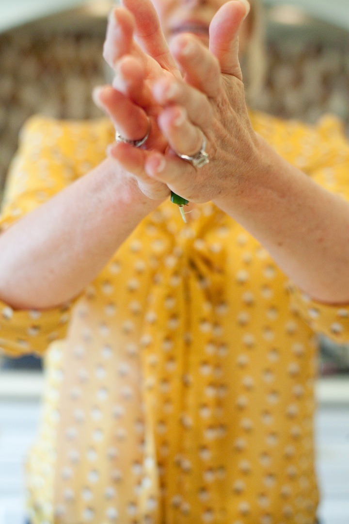 How to Handle a Hot Chili Pepper: a woman rolling a chili pepper between her hands to release the seeds 