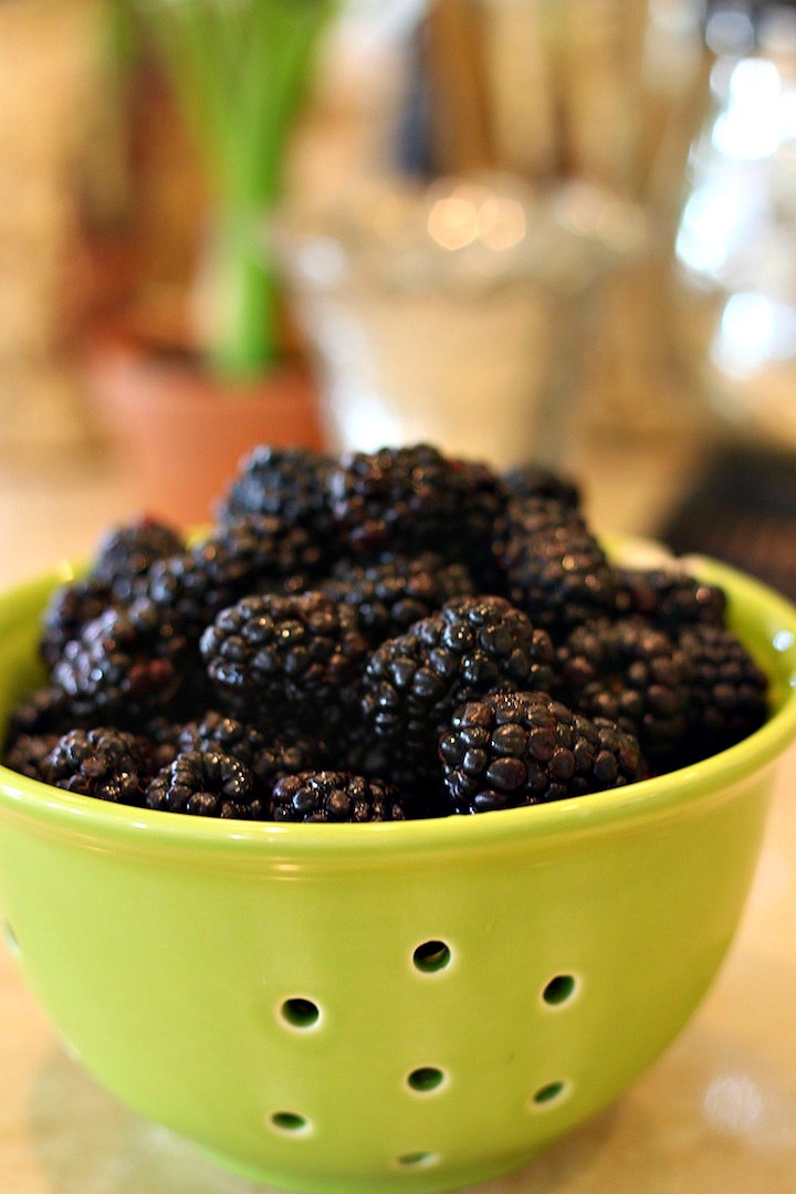 A lime green bowl filled with blackberries