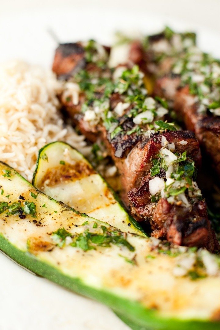 Beef Kabobs with Chimichurri, rice, and zucchini on white plate