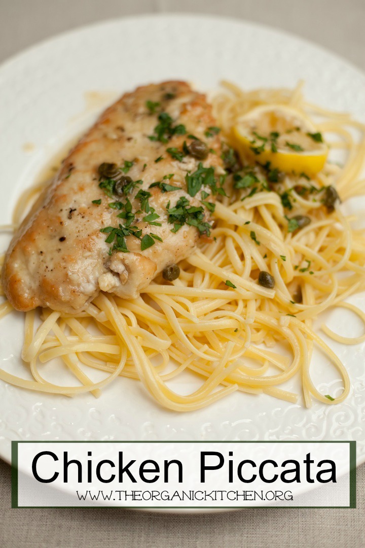 A white plate filled with Easy Chicken Piccata and pasta garnished with chopped parsley