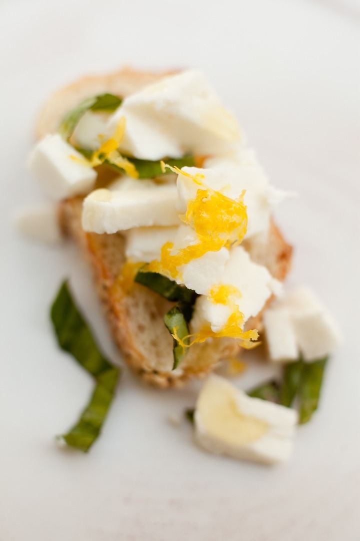 Easy Mozzarella Lemon Basil Crostini set on a marble surface