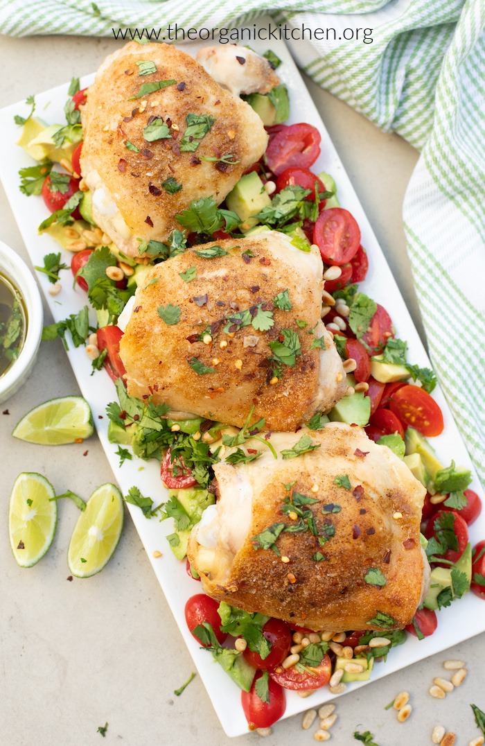 Spicy Lime Chicken on top of tomatoes and avocado, served on white platter and garnished with cilantro