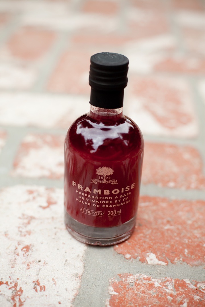 A bottle of raspberry vinegar on brick surface