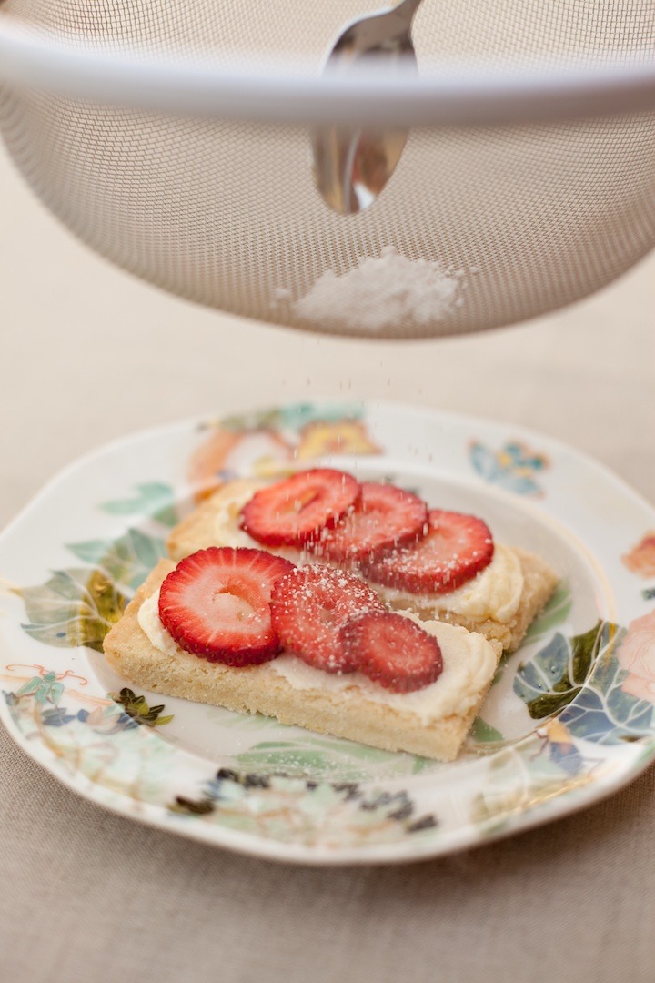 Lemon Shortbread Bars with Mascarpone being dusted with powdered sugar