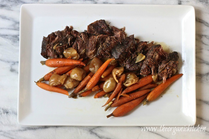 Slow Cooker Pot Roast with Shallots and Baby Carrots on white platter set on grey and white marble surface