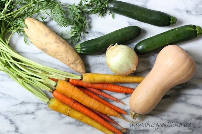 Butternut squash, zucchini, sweet potato, onion and carrots on a marble board for Roasted Vegetable Soup!