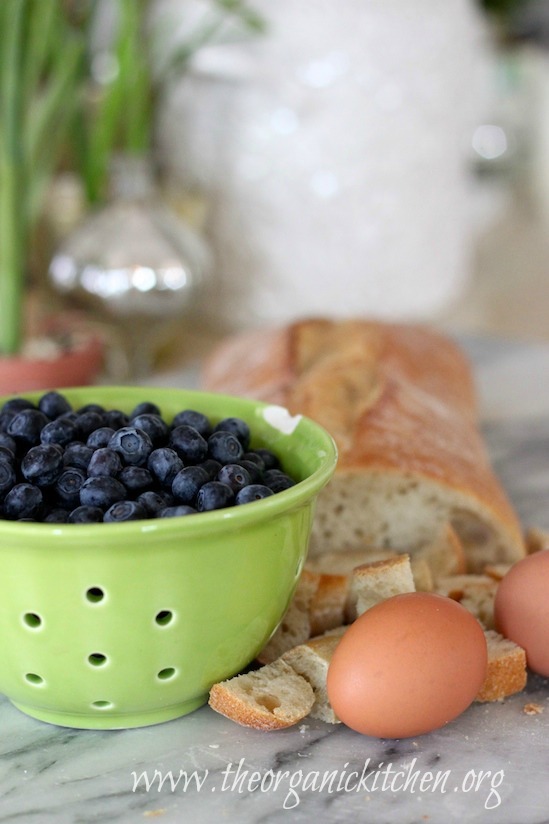 A bowl of blueberries, eggs, and French bread on marble surface. Heavenly Blueberry Bread Pudding From The Organic Kitchen