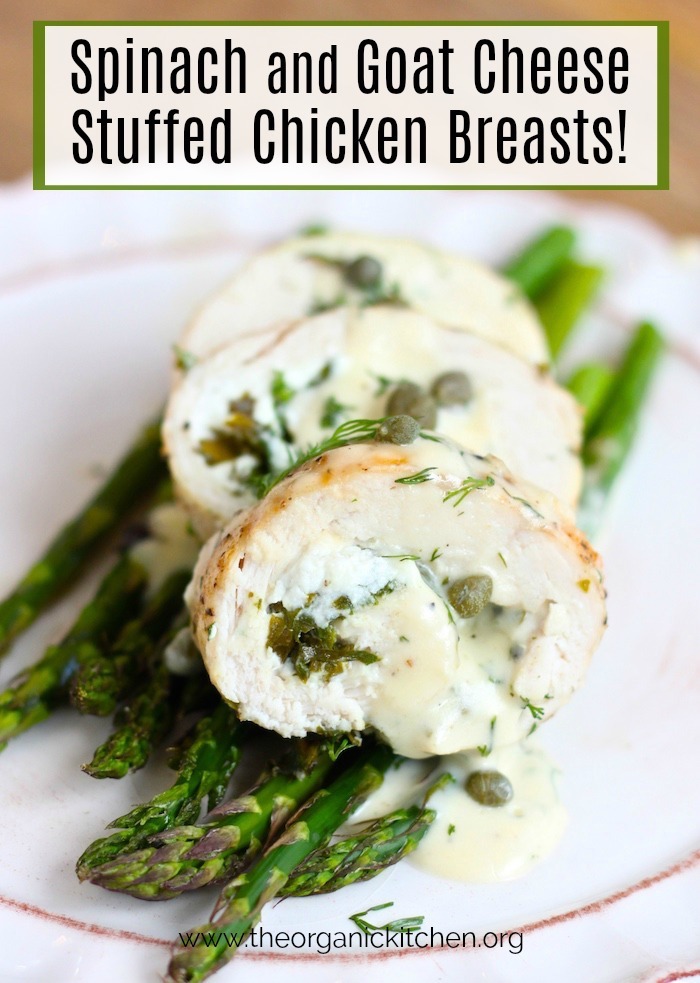 Spinach and Goat Cheese Stuffed Chicken Breasts on Asparagus with Dill Cream Sauce on a white plate