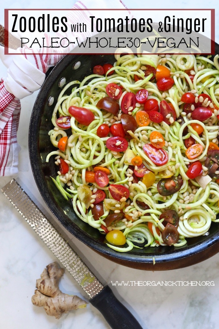 Zucchini Noodles with Ginger and Tomatoes in a black pan on marble table