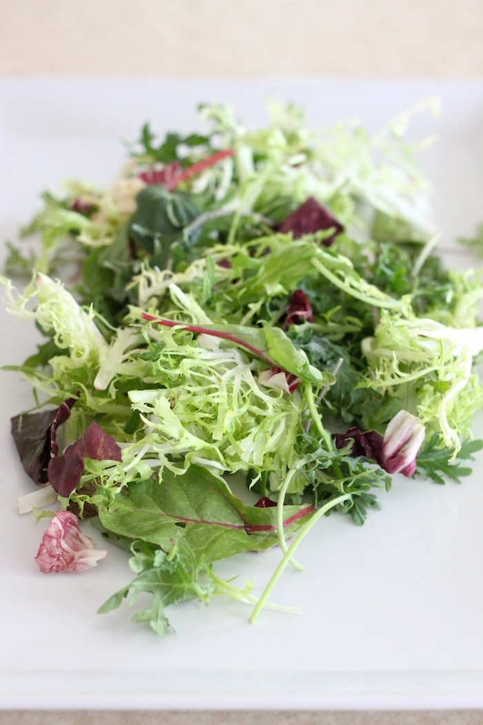 Greens on a white pate to be used in Spring Salad with Honey Chipotle Vinaigrette