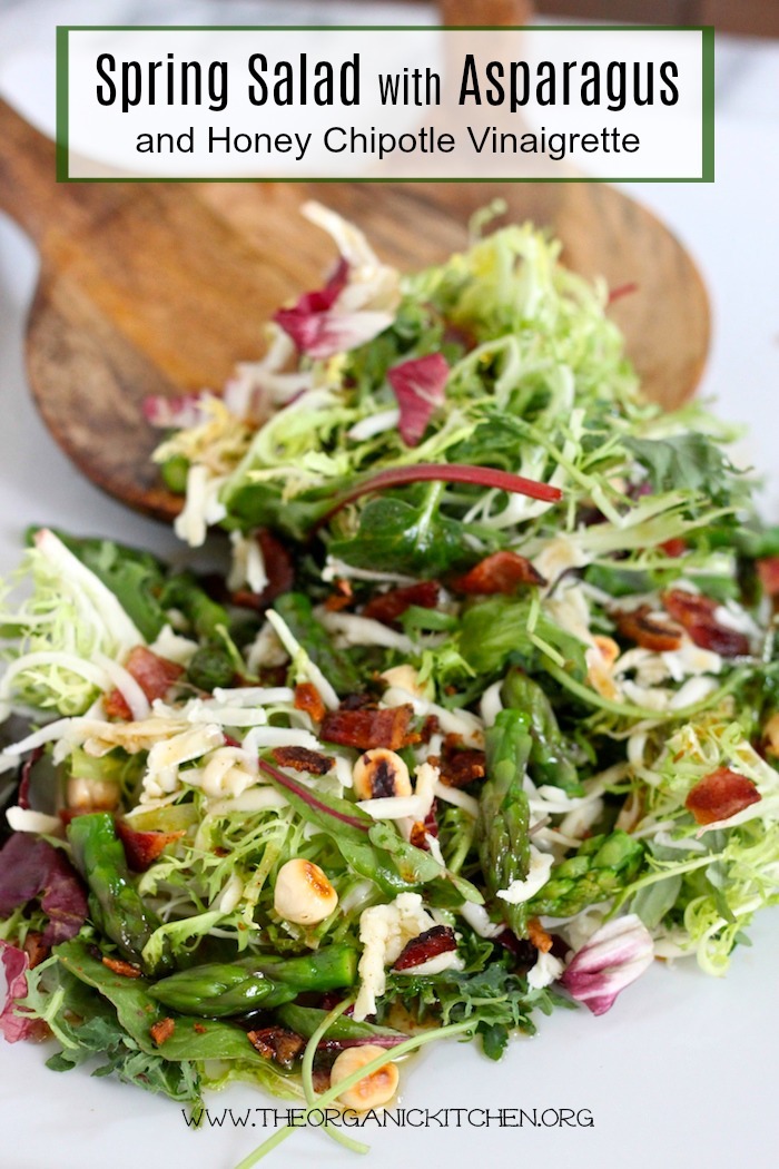 Spring Salad with Asparagus and Honey Chipotle Vinaigrette on white platter with wood serving spoons