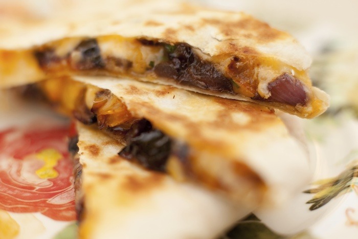 Caramelized Vegetable Quesadillas with black beans on colorful plate