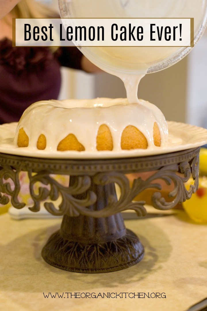The Best Lemon Cake Ever on cake plate being drizzled with lemon glaze