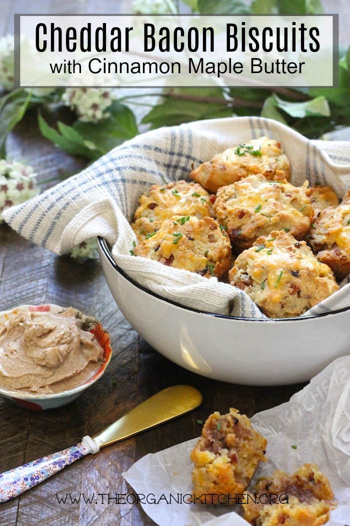 A bowl, lined with blue and white fabric filled Cheddar Bacon Biscuits with Maple Cinnamon Butter!