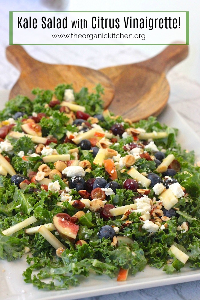 Kale Salad with Citrus Vinaigrette on large white platter with wooden salad tongs