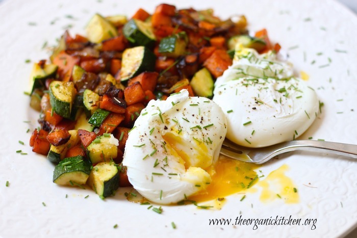 A white plate with colorful sweet potato and zucchini hash with two poached eggs as part of 12 Healthy, Delicious (Whole 30) Breakfast Recipes!