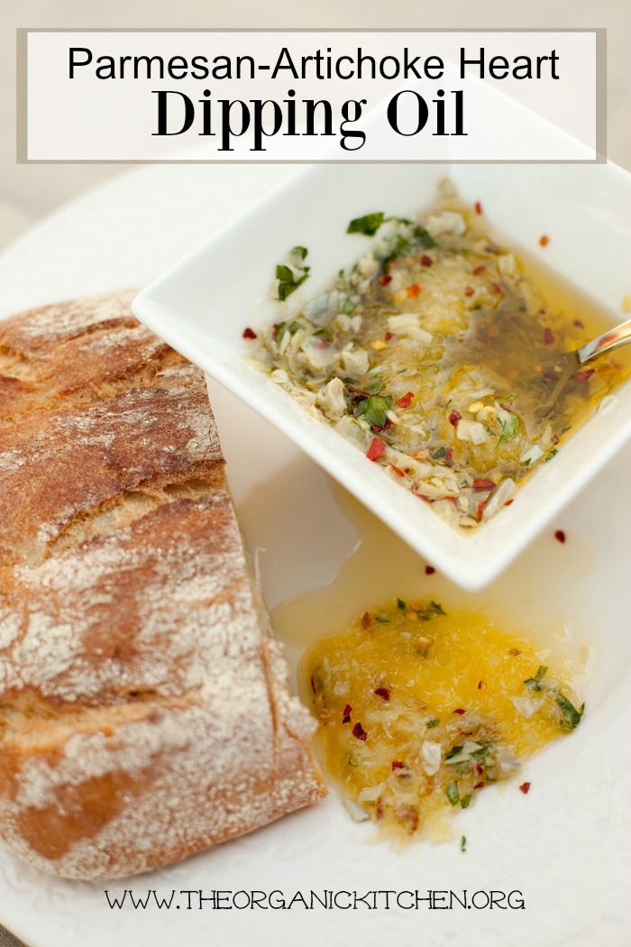 Parmesan Artichoke Heart Dipping Oil in a white bowl with loaf of bread