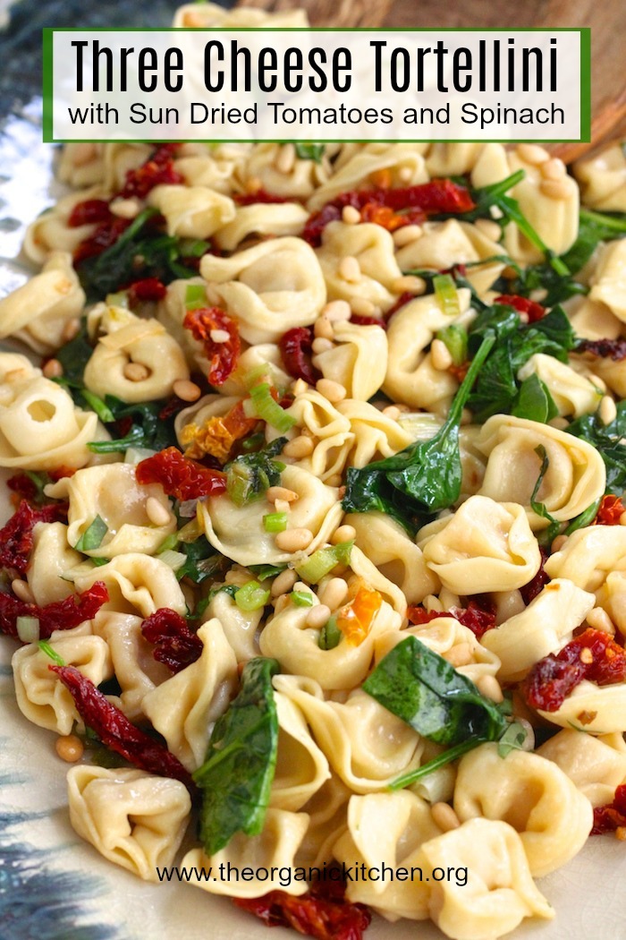 Three Cheese Tortellini with Spinach and Sun Dried Tomatoes on a blue platter