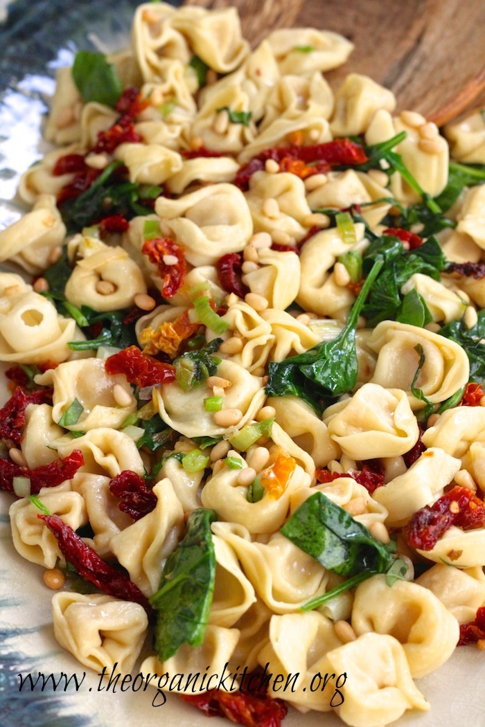 Three Cheese Tortellini with Spinach and Sun Dried Tomatoes garnished with pine nuts