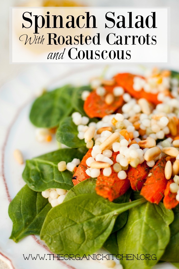 Baby Spinach Salad with Roasted Carrots and Israeli Couscous on white plate with scalloped edges