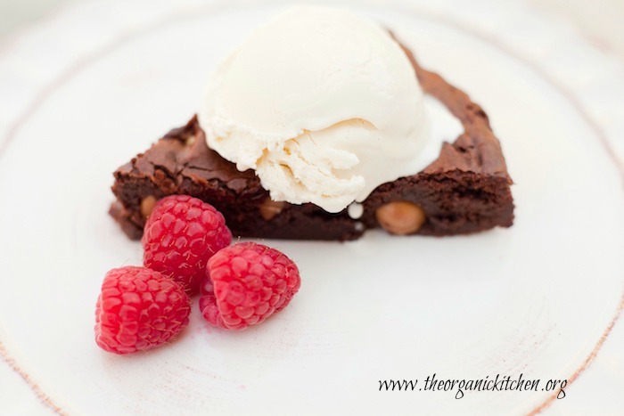 A horizontal photo of Browned Butter Brownies with Macadamia Nuts on white plate