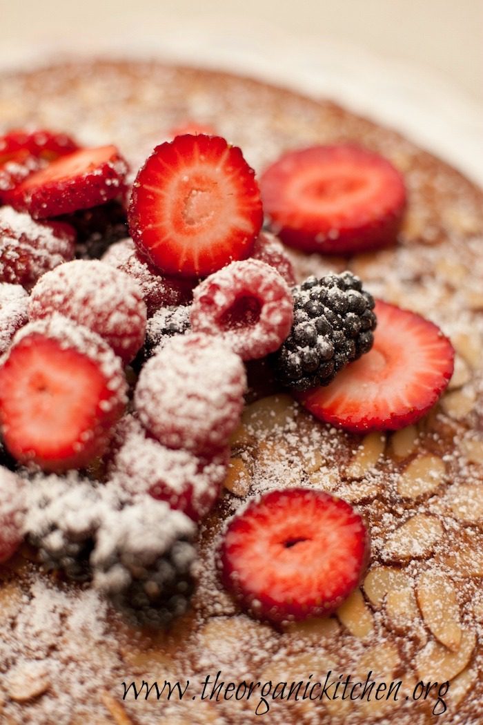 A close up of berries on top of Traditional Olive Oil Cake from The Organic Kitchen