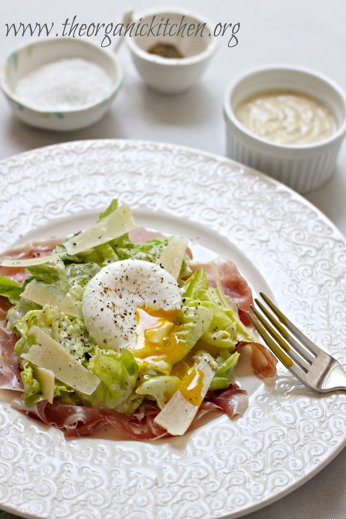 Caesar Salad with Prosciutto and Poached Egg garnished with Parmesan