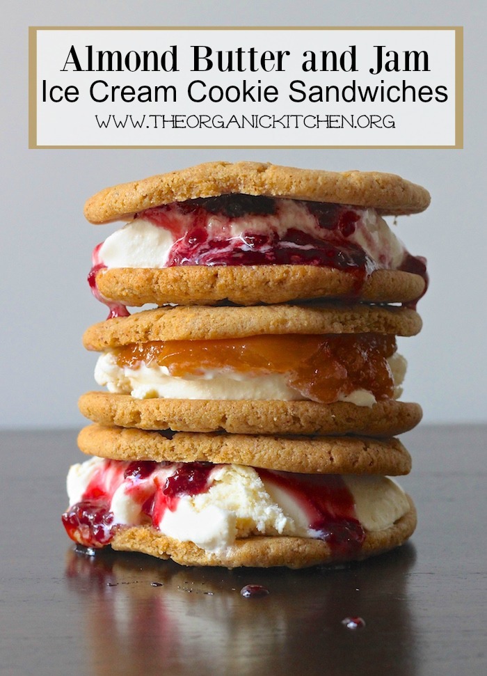 A stack of three Almond Butter and Jam Ice Cream Cookie Sandwiches with jam dripping down the sides