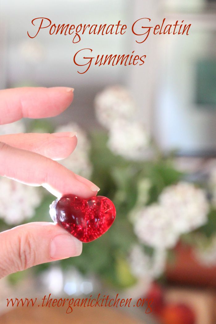 Tow fingers holding bright red Pomegranate Gelatin Gummies