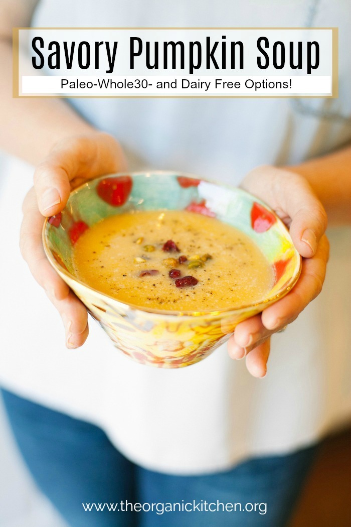 A female's hands holding a colorful bowl of Savory Pumpkin Soup with a dairy free option