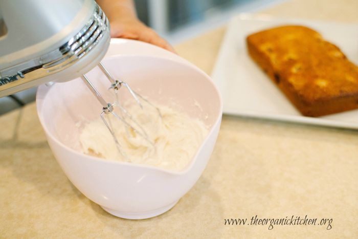 Lemon Raspberry Pound Cake A hand mixer blending the frosting for Lemon Raspberry Pound Cake