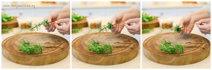 A woman showing how to strip rosemary sprigs for use in Whole30 Roasted Potatoes (with Rosemary Garlic Option)