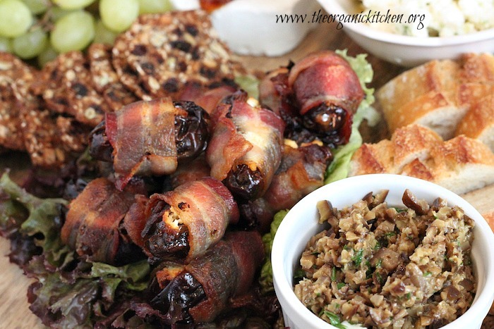 Goat Cheese Stuffed Bacon Wrapped Dates surrounded by grapes, olive tapenade and bread