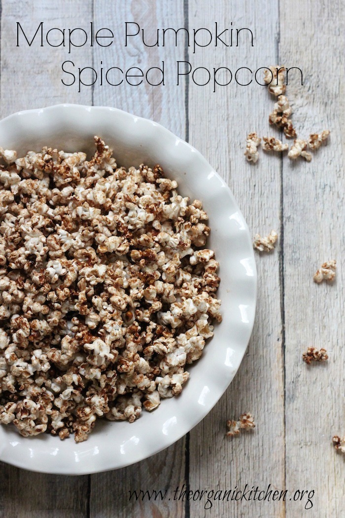 A white pie dish with scalloped edges filled with Maple Pumpkin Spiced Popcorn