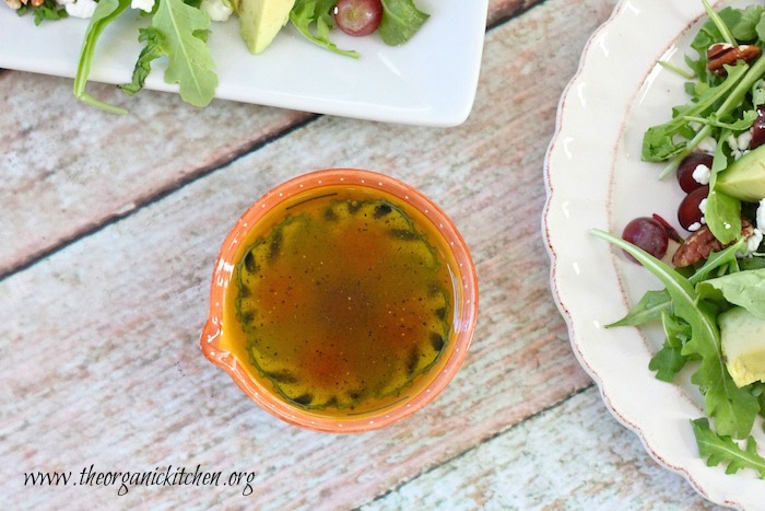 A small orange bowl with white balsamic dressing used for Blueberry and Avocado Salad