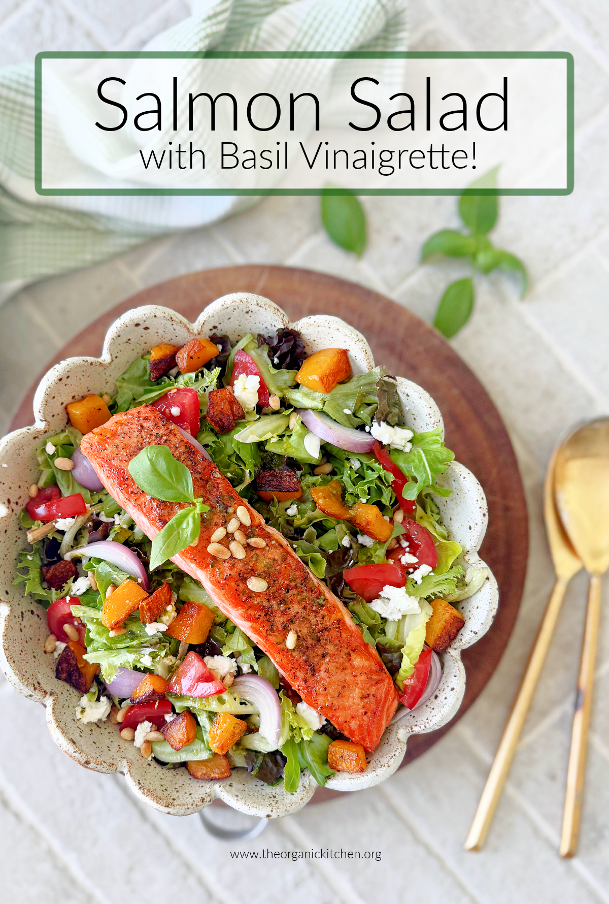 Salmon Salad with Basil Vinaigrette in white bowl with scalloped edges resting on grey brick floor with basil leaves in the background