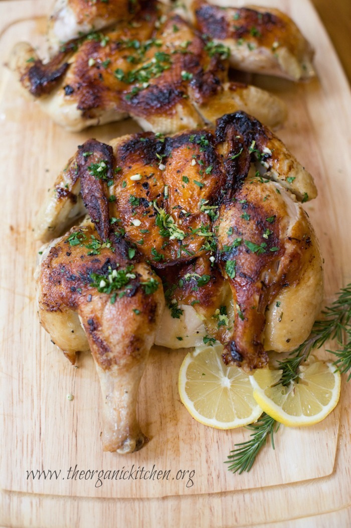 Chicken al Mattone after roasting, resting on a cutting board